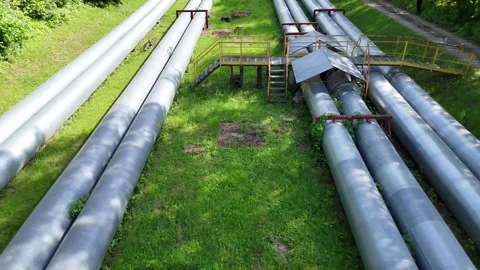 Aerial view of interconnected industrial pipes with green grass and walkways 库存影片 335662053
