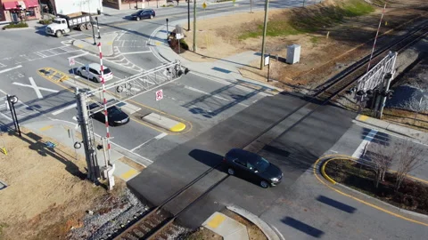 Aerial view of an intersection with vehicles and train rails Stock Footage 148403768
