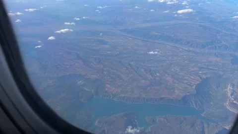 Aerial view of Italian landscape featuring a serene lake through airplane window Stock Footage 294103155