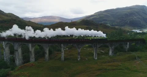 Aerial view of the Jacobite Steam Train crossing Glenfinnan Viaduct in Scotland Stock Footage 159672190