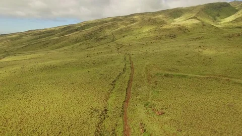 Aerial View Jib Down A Dusty Trail In  A Green Valley. Stock Footage 72640793