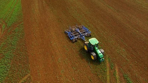 Aerial view of a John Deere 8379 R tractor pulls a plow trailer on a field Stock Footage 89280985