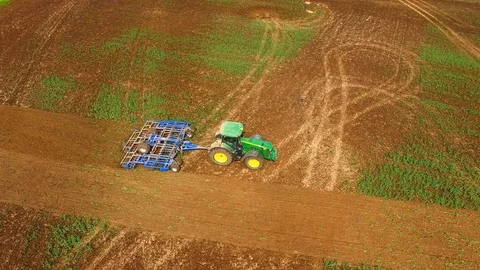 Aerial view of a John Deere 8379 R tractor pulls a plow trailer on a field Stock Footage 89283363