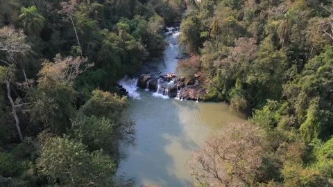 Aerial view of jungle stream cascading through rocky terrain surrounded by Stock Footage 302956435