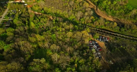 Aerial view of junk yard in with stacks of used cars in wooded area in Video stock 239036696