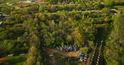 Aerial view of junk yard in with stacks of used cars in wooded area in Video stock 239036800