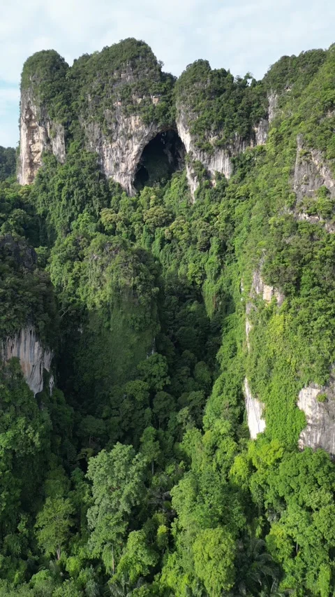 Aerial view of karst mountains with cave and lush greenery in Krabi, Thailand Stock Footage 334906176