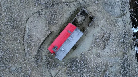 Aerial view of Kinbreack Bothy with its distinctive red roof set against the Stock Footage 345589429