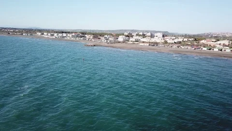 Aerial view of A Kite surfer sails in front of a sand beach in a sunny windy day Stock Footage 106538645