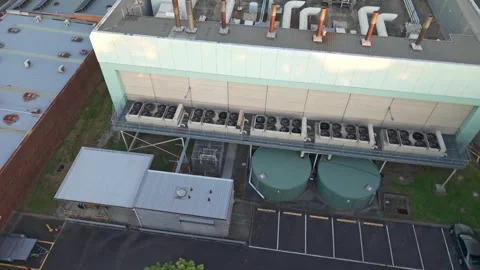 Aerial view of Knox data centre facility at dusk with green cooling towers Stock Footage 348043393