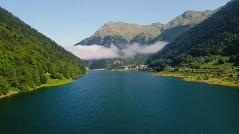 Aerial view of Lac de Fabrèges, Pyrenees, France. Dam surrounded green mountains Stock Footage 301642553