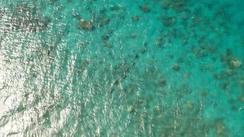 Aerial view of the lagoon sea surface with coral reef and sun rays Stock Footage 113920060