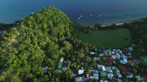 Aerial view of lagoon surrounded by lush green hills and ocean on Apo Island 스톡 동영상 332615599