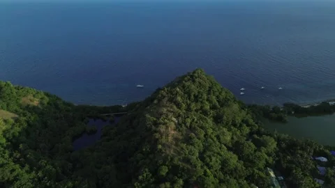 Aerial view of lagoon surrounded by lush green hills and ocean on Apo Island Video stock 332615699