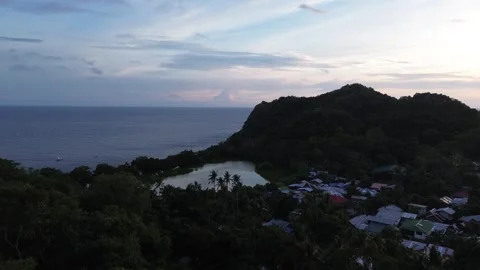 Aerial view of lagoon surrounded by lush green hills and ocean on Apo Island Stock-Footage 332615726