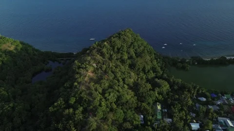 Aerial view of lagoon surrounded by lush green hills and ocean on Apo Island Stock-Footage 332615836