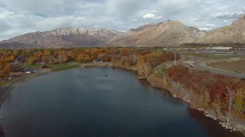 Aerial view of lake below mountains with people in canoe Stock Footage 32243203