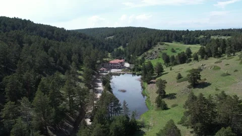Aerial view of the lake between forests and green hills Stock Footage 294084488