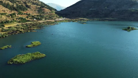 Aerial view of the lake between two mountains. Floating islands on the lake. Stock Footage 258439573