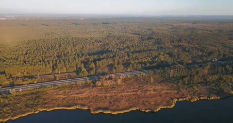 Aerial view of a lake, forest and highway with moving cars Stock Footage 345370712