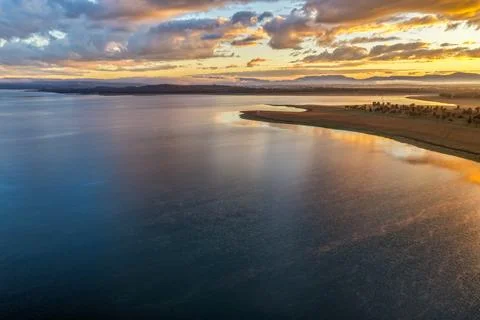 Aerial view of Lake Keepit beneath a golden sunrise sky, featuring campsite.. Stock Photos