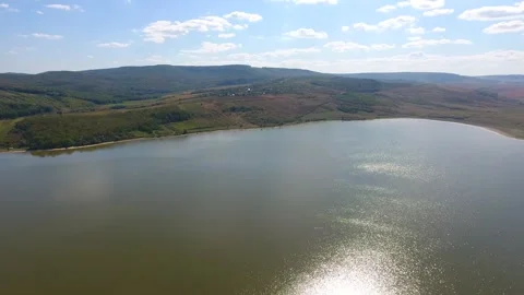 Aerial view of lake, sunset time, sun reflecting in the water Video stock 249990633