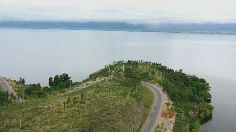 Aerial view of lakeside hillside meadow gentle mountain lake distant view in Stock Footage 337923178