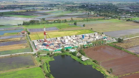 Aerial View of Land Drilling Rig and Oilfield Facility in Rice Fields Stock Footage 336583267