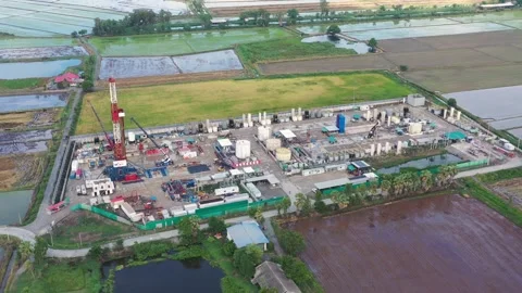 Aerial View of Land Drilling Rig and Oilfield Facility in Rice Fields Stock Footage 336583307