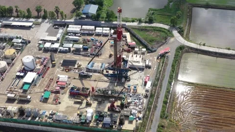 Aerial View of Land Drilling Rig and Oilfield Facility in Rice Fields Stock Footage 336583317