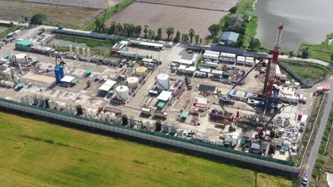 Aerial View of Land Drilling Rig and Oilfield Facility in Rice Fields Stock Footage 336583328