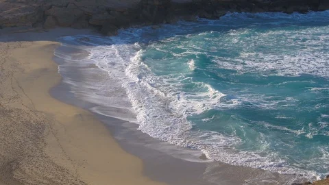 Aerial view of large beach with blue white and foamy waves hitting white sand Stock Footage 101564324
