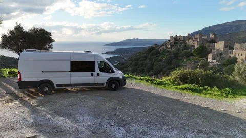 Aerial view of a large camper van parked near historic stone buildings and sceni Video stock 301446733