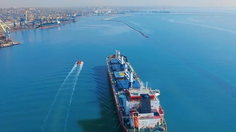 Aerial view. Large cargo ship enters the port city with port cranes. Vidéo 107445022