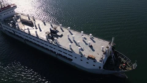 Aerial view of a large cargo ship cruising through calm waters, sunlight Stock Footage 289202644