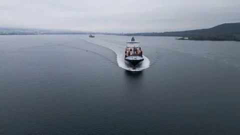 Aerial view of large container ship moving across calm sea, leaving wake behind. Stock Footage 325740867