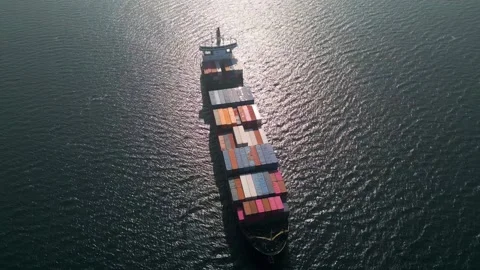 Aerial view of a large container ship sailing in the ocean, strong sun gleam 库存影片 333554461