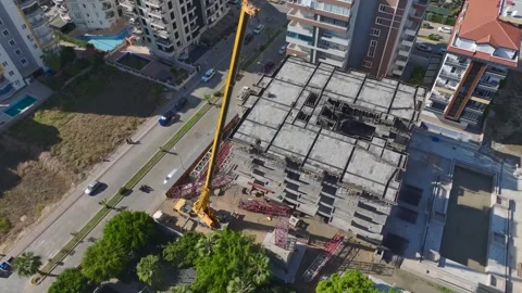 Aerial View: A large crane is lifted into position as workers and engineers Stock Footage 296019334