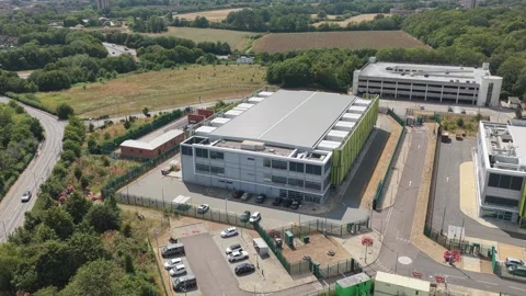 Aerial View of a Large Data Center Facility Surrounded by Green Trees During a Stock Footage 345681958