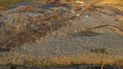 Aerial view, large garbage pile at sorting site. Camera is zoom out Stock Footage 141560772