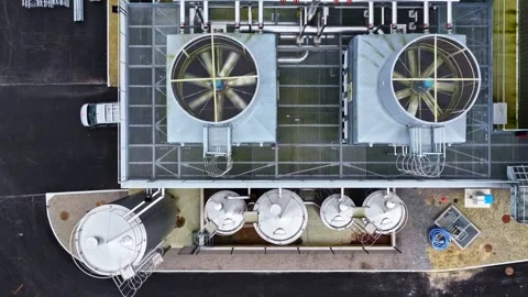 Aerial view of large HVAC cooling fans on a roof and steel tanks Stock-Footage 332628464