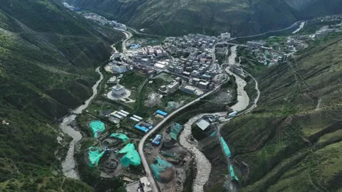 Aerial view of large intermountain town divided by winding river in steep valley Stock Footage 336698137