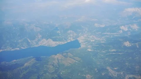 Aerial view of a large lake surrounded by mountains in 4K slow motion 60fps Stock Footage 286299373