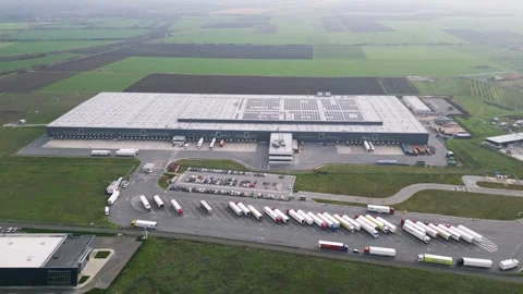 Aerial view of a large logistics warehouse with loading docks and trucks Stock Footage 323437266