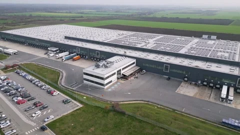 Aerial view of a large logistics warehouse with loading docks and trucks Stock Footage 323437589