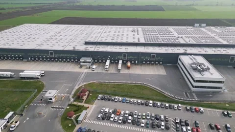Aerial view of a large logistics warehouse with loading docks and trucks Stock Footage 323437666