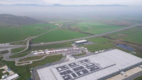 Aerial view of a large logistics warehouse with solar panels near highway Stock Footage 323440538