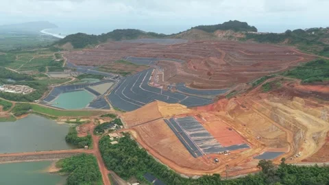 Aerial view of a large open pit mining operation near the ocean Stock Footage 328919354