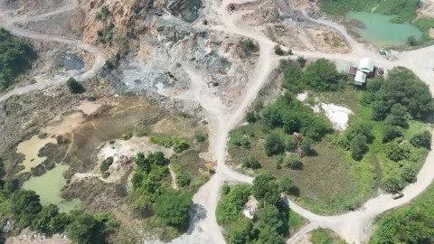 Aerial view of a large open pit mine surrounded by lush green tropical forest. Stock Footage 341835327