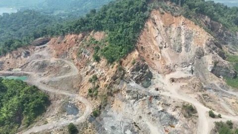 Aerial view of a large open pit mine surrounded by lush green tropical forest. Stock Footage 341870609